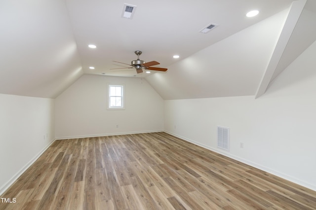 additional living space with light wood finished floors, recessed lighting, ceiling fan, vaulted ceiling, and baseboards