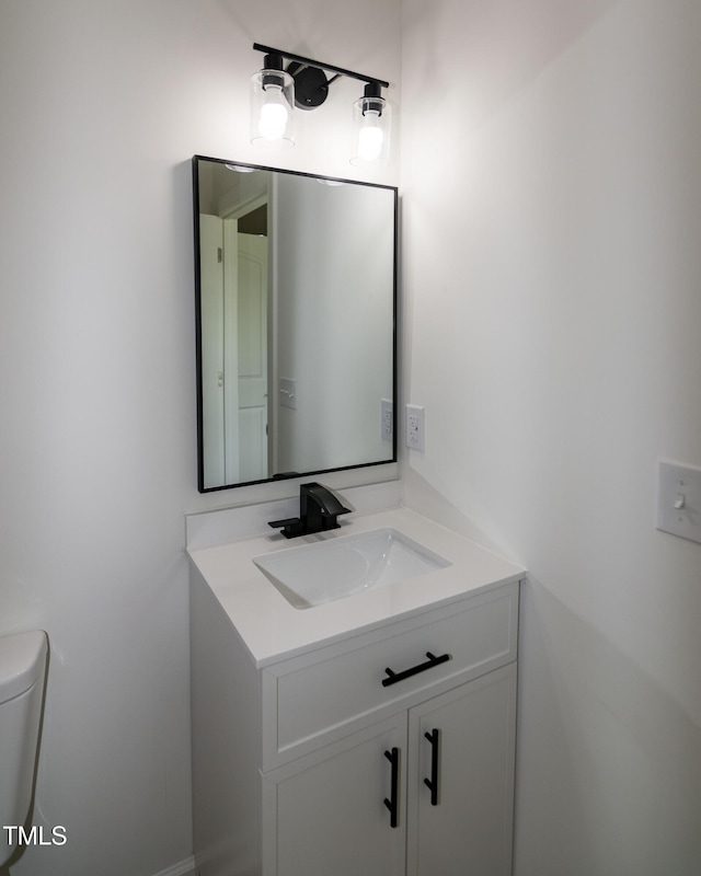 half bathroom featuring vanity and toilet