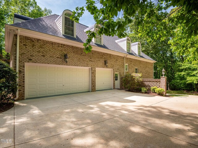540 Vista Del Lago Ln, Wake Forest, NC 27587 - view of property exterior featuring concrete driveway, brick siding, a shingled roof, and an attached garage