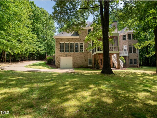 540 Vista Del Lago Ln, Wake Forest, NC 27587 - rear view of house with brick siding, stairway, concrete driveway, a lawn, and a garage