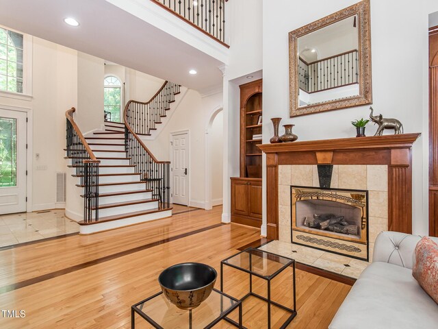 540 Vista Del Lago Ln, Wake Forest, NC 27587 - living area featuring a high ceiling, baseboards, stairway, wood finished floors, and a fireplace