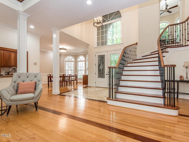 540 Vista Del Lago Ln, Wake Forest, NC 27587 - foyer entrance featuring ornate columns, hardwood / wood-style floors, ornamental molding, stairway, and a chandelier