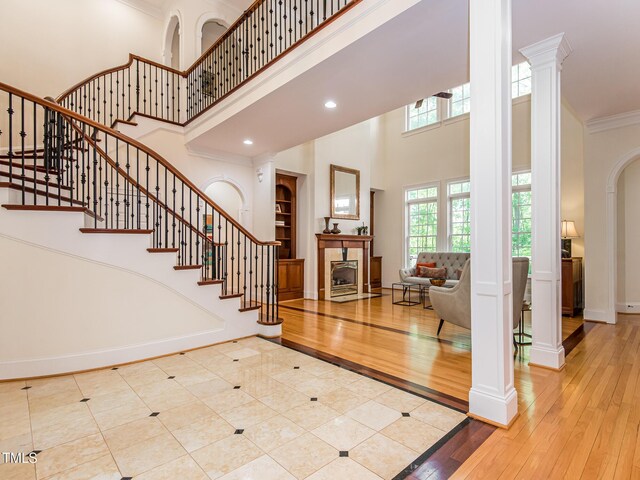 540 Vista Del Lago Ln, Wake Forest, NC 27587 - entrance foyer featuring a towering ceiling, ornate columns, a tile fireplace, stairway, and hardwood / wood-style flooring
