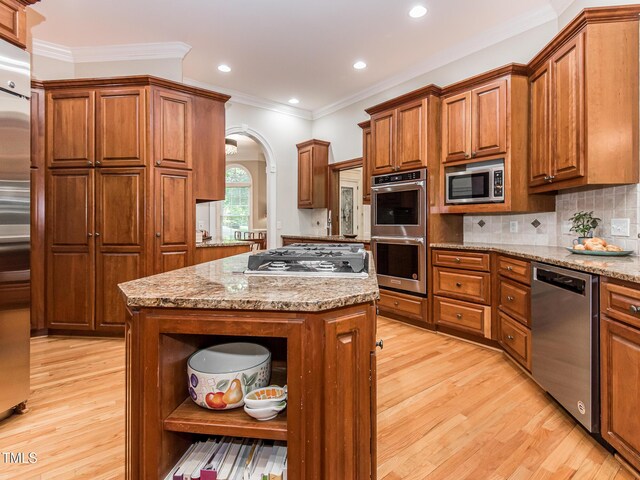 540 Vista Del Lago Ln, Wake Forest, NC 27587 - kitchen featuring open shelves, appliances with stainless steel finishes, light wood-style floors, brown cabinets, and ornamental molding