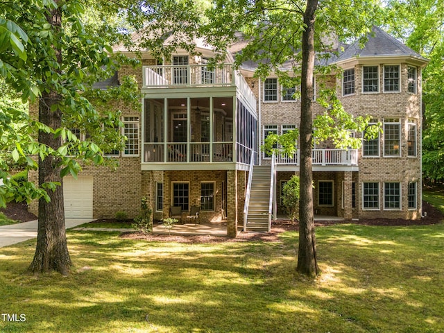 540 Vista Del Lago Ln, Wake Forest, NC 27587 - rear view of house featuring a balcony, brick siding, a yard, a sunroom, and driveway