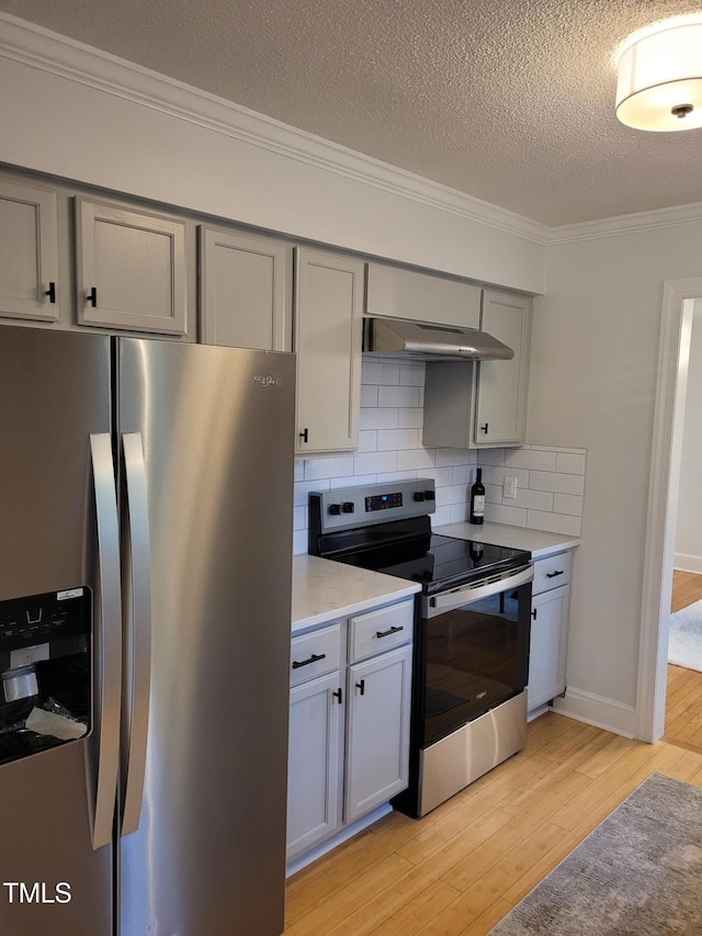 kitchen featuring stainless steel appliances, gray cabinetry, light wood-style flooring, ornamental molding, and light countertops