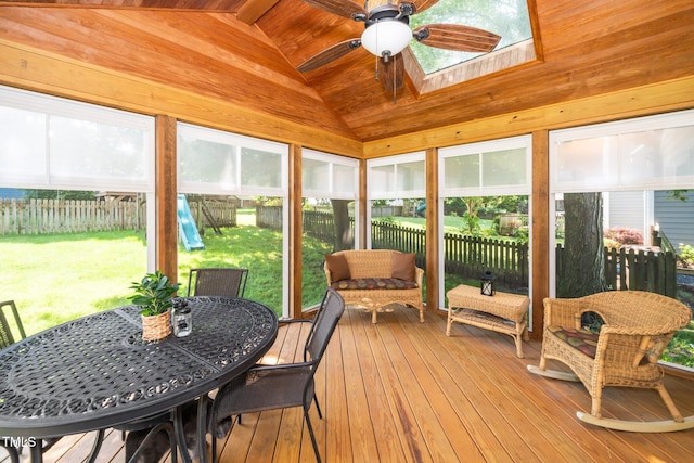 sunroom featuring a ceiling fan, a skylight, vaulted ceiling, and outdoor dining space