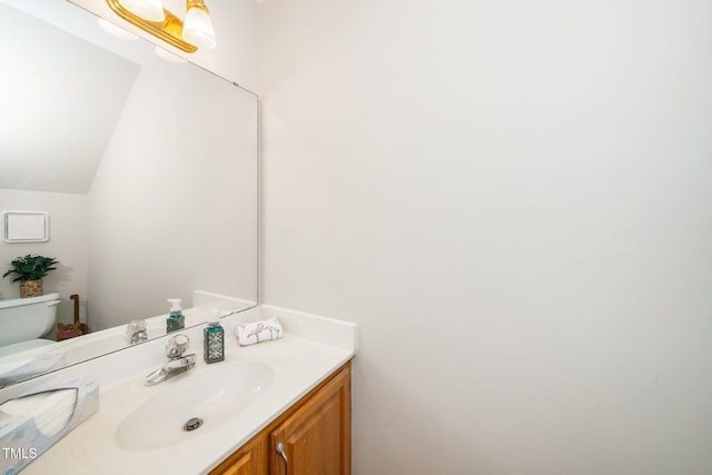 half bath featuring vanity and toilet