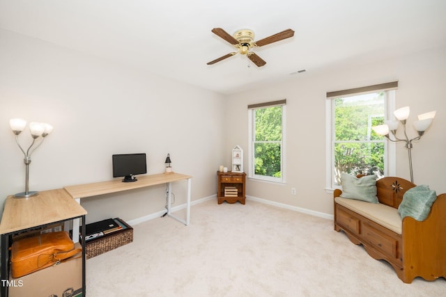 office area with a ceiling fan, baseboards, and light carpet