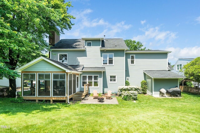 back of property featuring a sunroom, a chimney, a patio, a fire pit, and roof with shingles