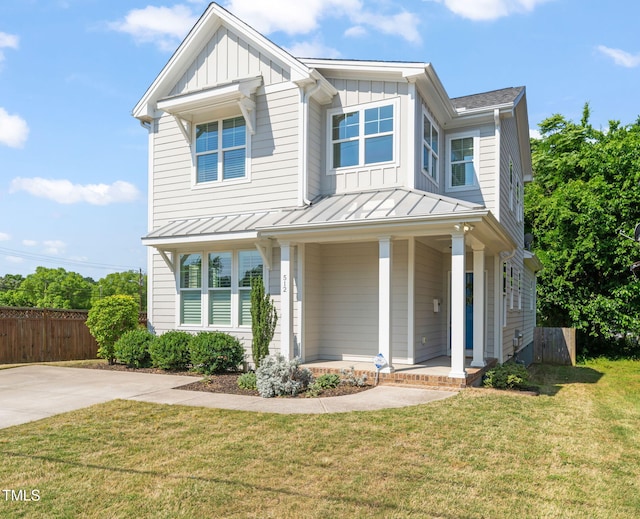 view of front of property featuring fence, board and batten siding, a porch, and a front yard