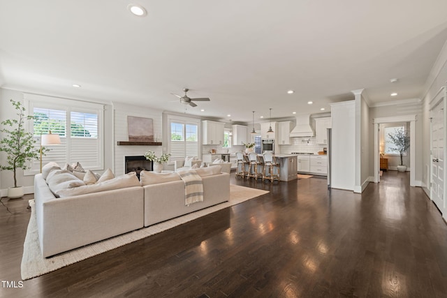 living area with a ceiling fan, crown molding, dark wood finished floors, baseboards, and recessed lighting