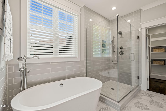 full bathroom with a freestanding bath, tile patterned flooring, recessed lighting, tile walls, and a stall shower
