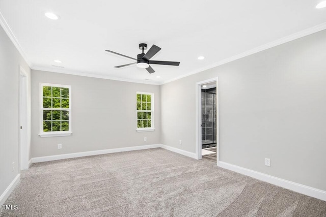 carpeted empty room featuring crown molding, baseboards, ceiling fan, and a wealth of natural light