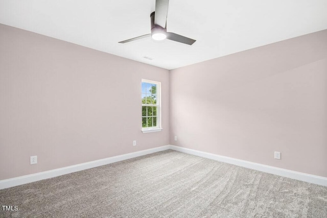 carpeted empty room with a ceiling fan and baseboards
