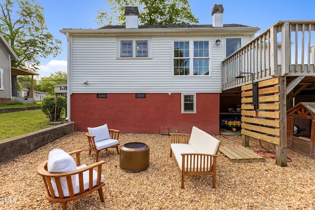 back of house featuring a wooden deck, a chimney, and stairs