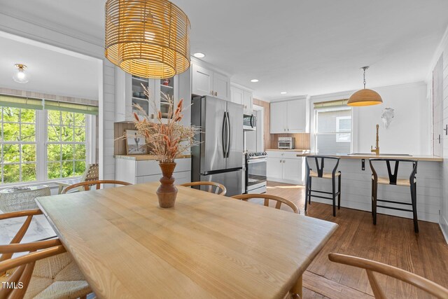 dining area featuring recessed lighting, ornamental molding, a toaster, and light wood-style flooring