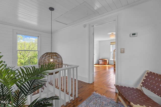 corridor with wood-type flooring, wooden ceiling, and an upstairs landing