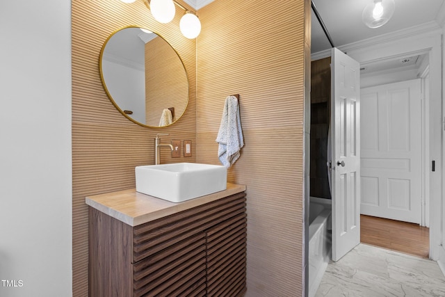 full bath featuring marble finish floor, vanity, and crown molding
