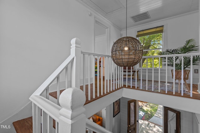stairway featuring ornamental molding and visible vents