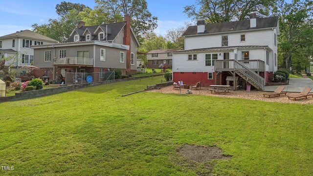 back of property featuring stairway, a patio area, a chimney, a deck, and a fire pit
