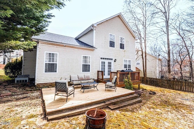 rear view of property with roof with shingles, french doors, an outdoor living space with a fire pit, a wooden deck, and fence