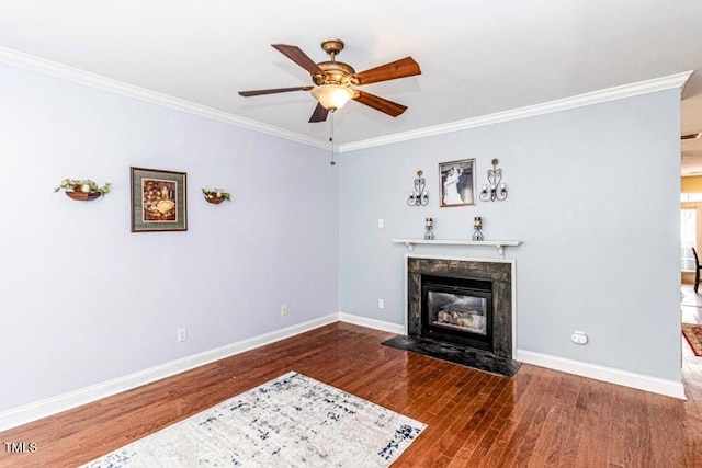 living area featuring baseboards, a ceiling fan, ornamental molding, and wood finished floors