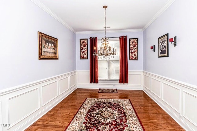 interior space with an inviting chandelier, crown molding, and wood finished floors