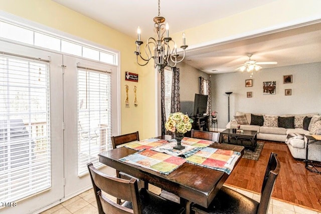dining space with light wood-type flooring and ceiling fan with notable chandelier