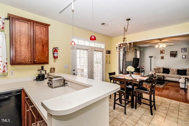 kitchen featuring pendant lighting, a peninsula, black dishwasher, light countertops, and open floor plan