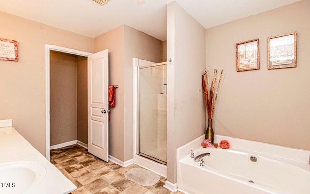 bathroom featuring a garden tub, a shower stall, a sink, double vanity, and baseboards