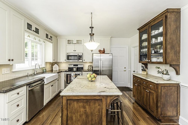 kitchen featuring a center island, appliances with stainless steel finishes, a sink, and dark wood finished floors