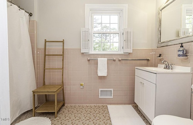 full bath featuring visible vents, toilet, tile walls, and vanity