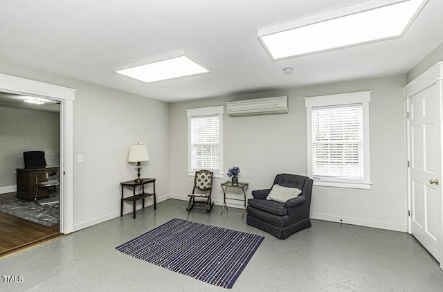 sitting room with baseboards and an AC wall unit