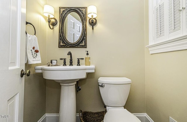 bathroom featuring baseboards and toilet