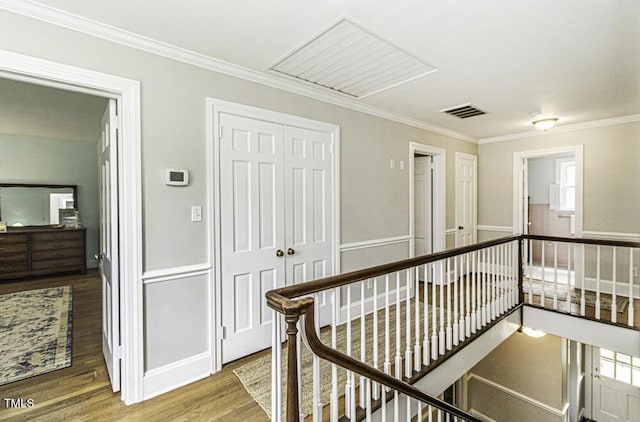 hallway featuring an upstairs landing, visible vents, crown molding, and wood finished floors