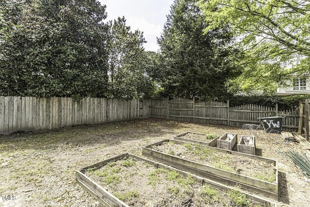 view of yard with a garden and a fenced backyard