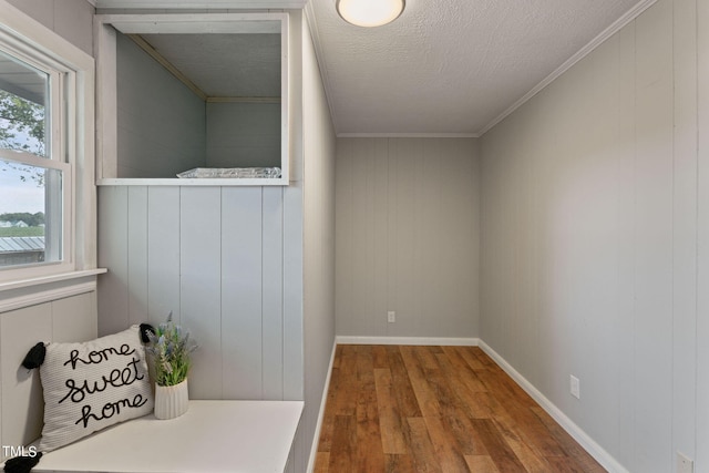 interior space with crown molding, wood finished floors, and wooden walls