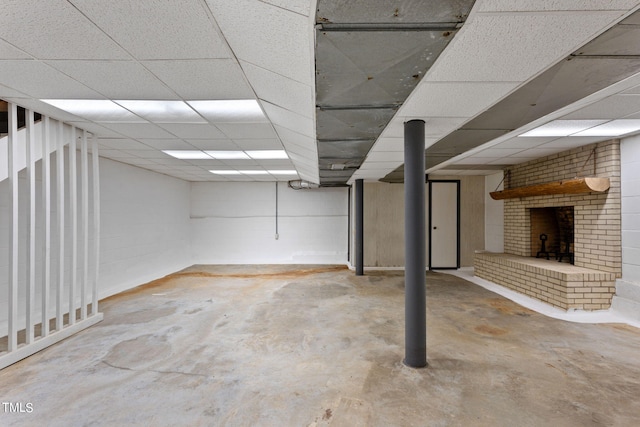 finished below grade area with a paneled ceiling and a fireplace