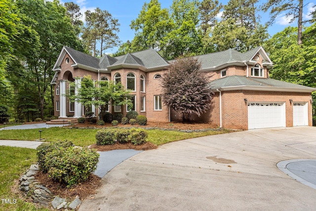 view of front facade with driveway, a front lawn, brick siding, and a garage