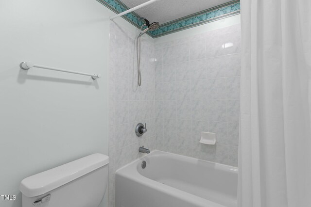 bathroom featuring toilet, shower / tub combo with curtain, and a textured ceiling