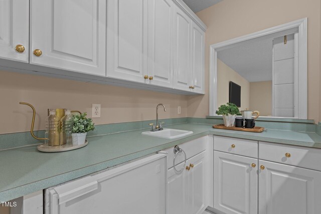 kitchen with light countertops, white cabinets, and a sink