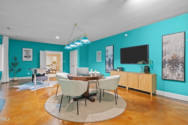 dining space with concrete floors, recessed lighting, a textured ceiling, and baseboards