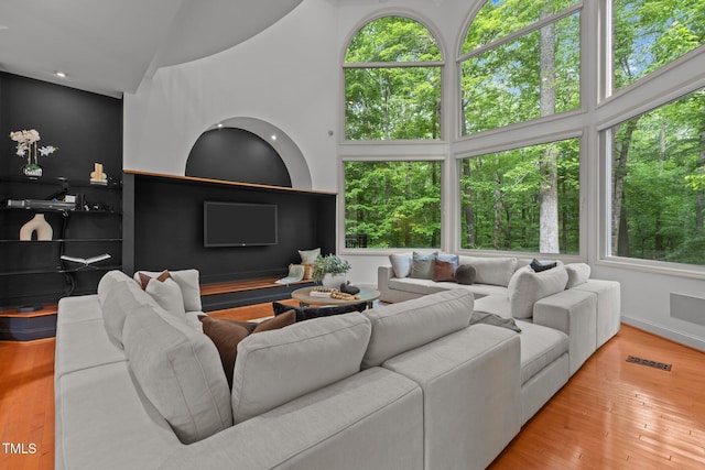 living room with visible vents, hardwood / wood-style flooring, and baseboards