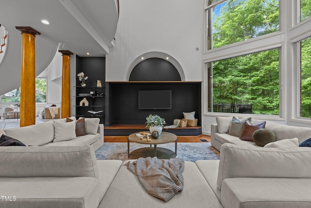 living room with recessed lighting, wood finished floors, built in features, and plenty of natural light