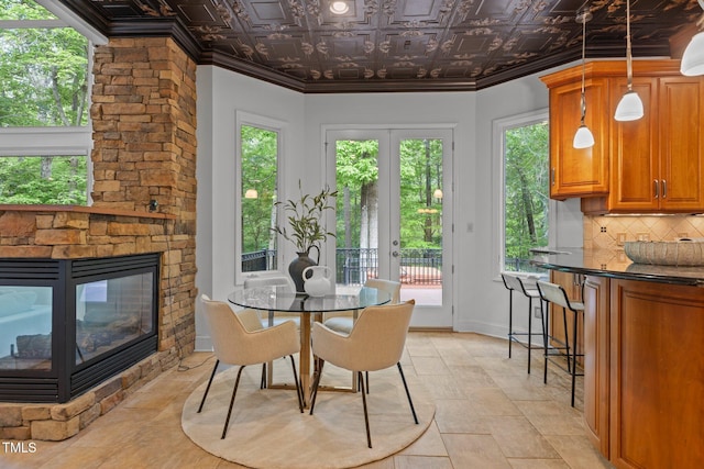 dining area with ornamental molding, baseboards, an ornate ceiling, and a fireplace