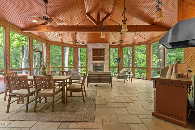 sunroom / solarium with stone tile flooring and wood ceiling