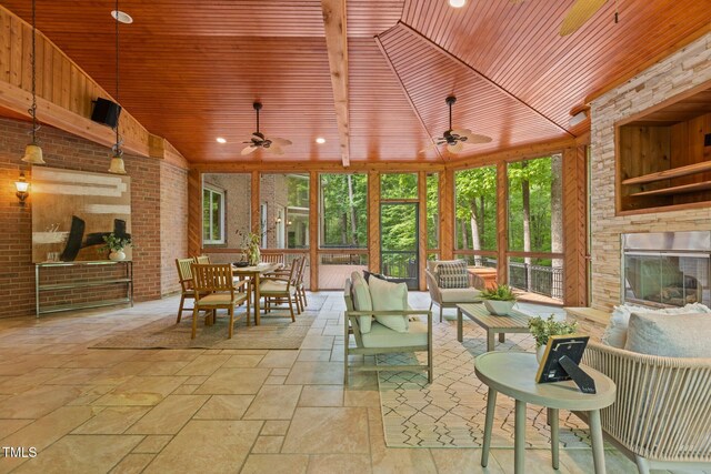 sunroom featuring stone tile floors, floor to ceiling windows, vaulted ceiling, and wooden ceiling