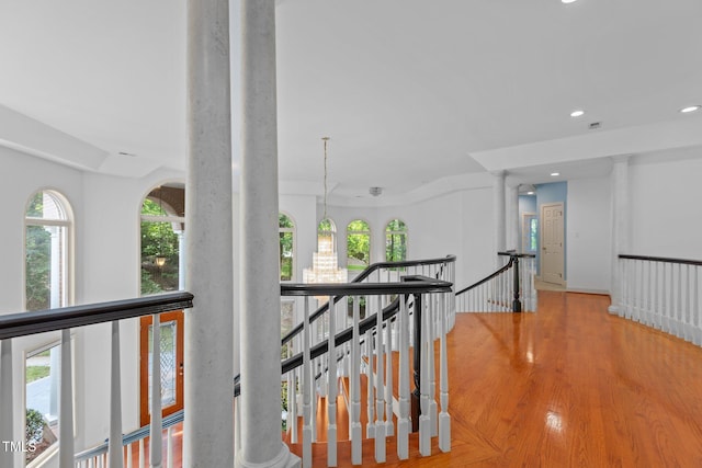 corridor featuring recessed lighting, an upstairs landing, wood finished floors, and ornate columns