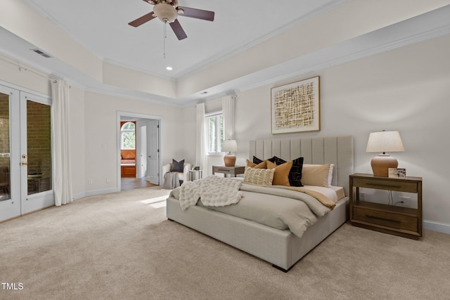 carpeted bedroom featuring visible vents, a tray ceiling, baseboards, ornamental molding, and access to outside